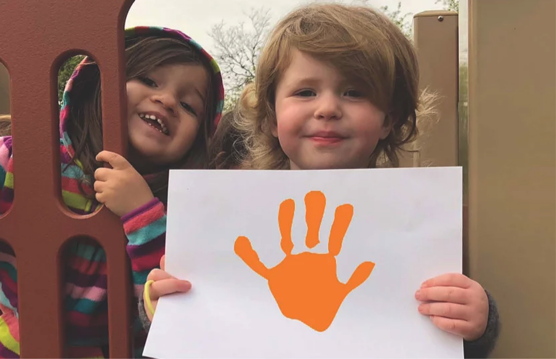 Child Holding Up Hand Painting