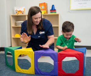 Brighton Center Teacher with Child Learning Sensory Processing while Playing a Sensory Safe Activity